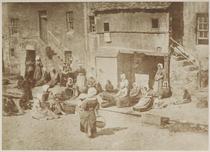 St Andrews Fisherfolk. Group of women and children seated in the street baiting lines. [Stevenson (1981), 'St Andrews 35,' there titled: 'North Street, Fishergate, women and children baiting the lines
