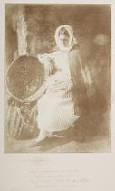 Elizabeth Johnston, Newhaven. Full-length portrait of the fisherwoman Elizabeth Johnston, seated looking downwards with a pensive expression, her right arm resting on an arrangement of two wicker fish