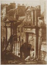 The Martyr's Tomb,Grayfriars ??? Edinburgh. View of the Martyr's Memorial and the McCulloch Monument, with a couple in conversation in the foreground. She is seated with her back to the camera, he lea